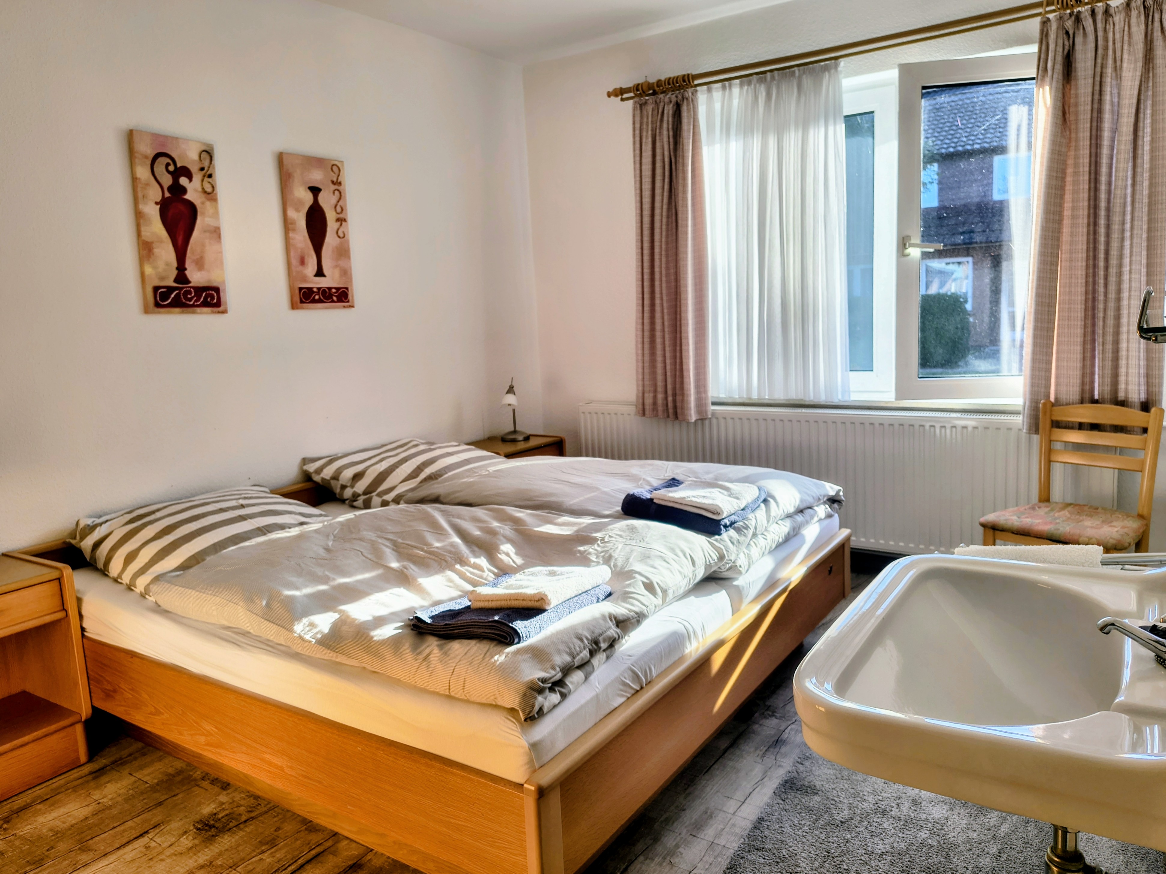 Schlafzimmer mit Doppelbett und Waschbecken